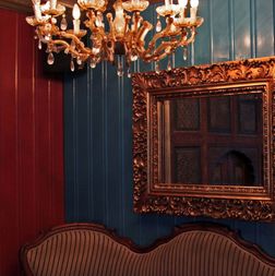 Speil og lysekrone og gammel rokokksofa på Tullins Café